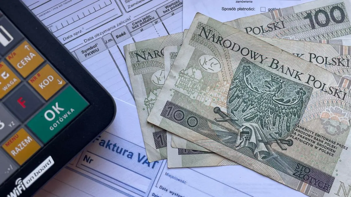 Банкноти по 100 злотих на фактурі VAT поруч із калькулятором. Фото: Niepoddawajsie.pl Luk, Pexels